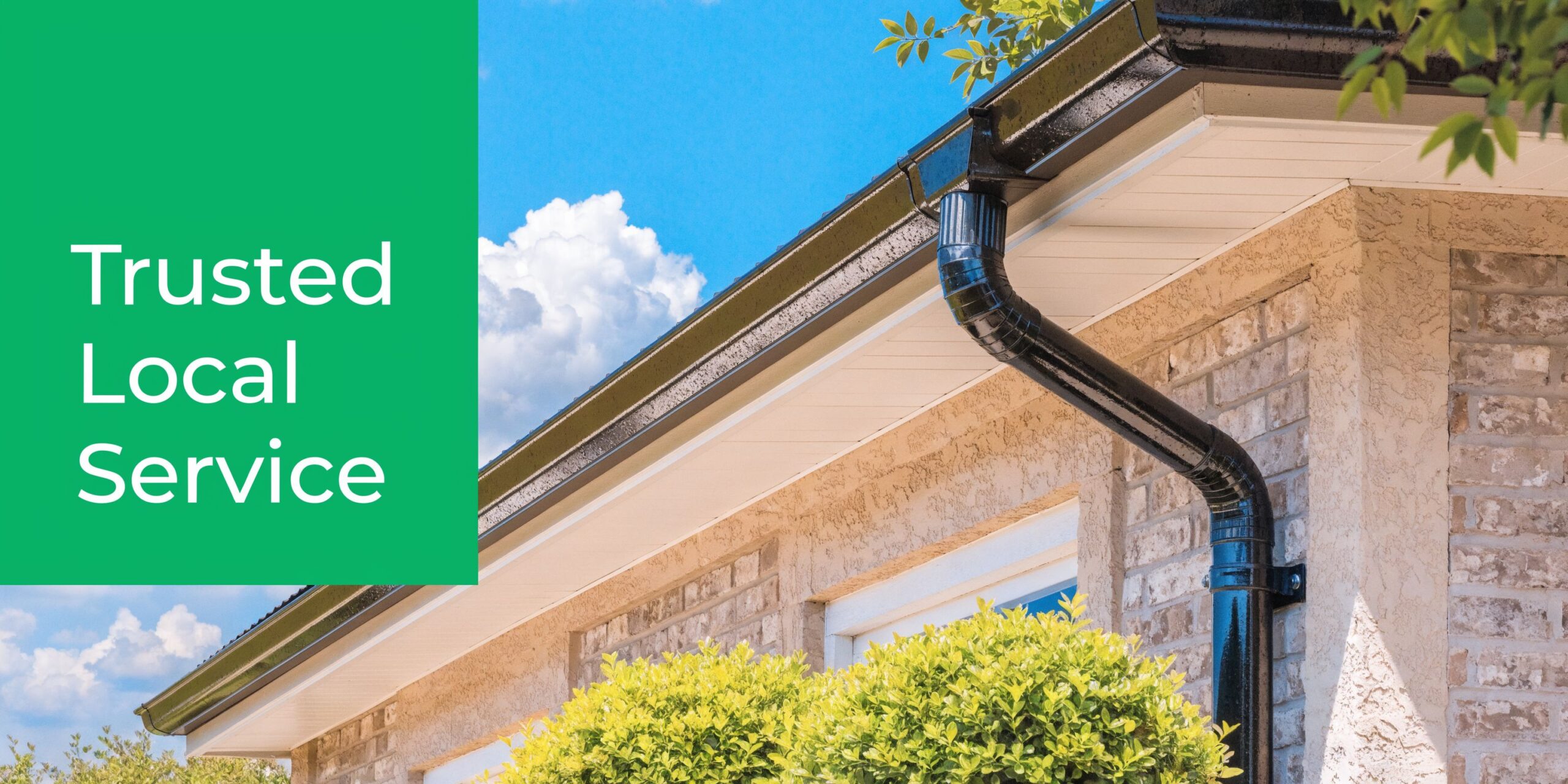 A close up view of a home exterior featuring a black gutter system on a brick wall.