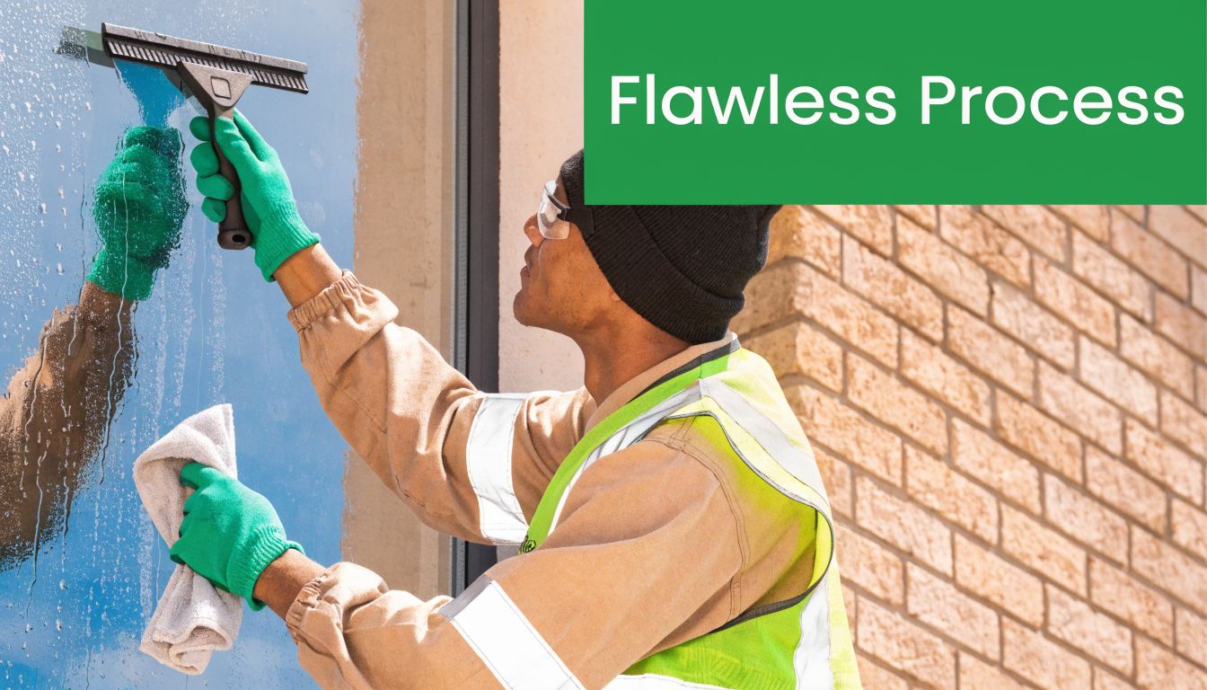 A professional window cleaner wearing a safety vest and gloves cleaning a window on a building